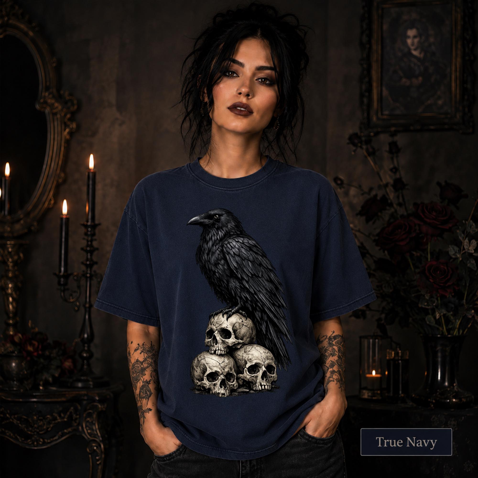 Gothic raven graphic tee with detailed black feathers and stacked skull artwork.