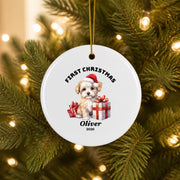 Round white personalized Christmas keepsake ornament featuring Santa, festive red accents, and custom name Oliver, displayed on an evergreen branch with glowing holiday lights.