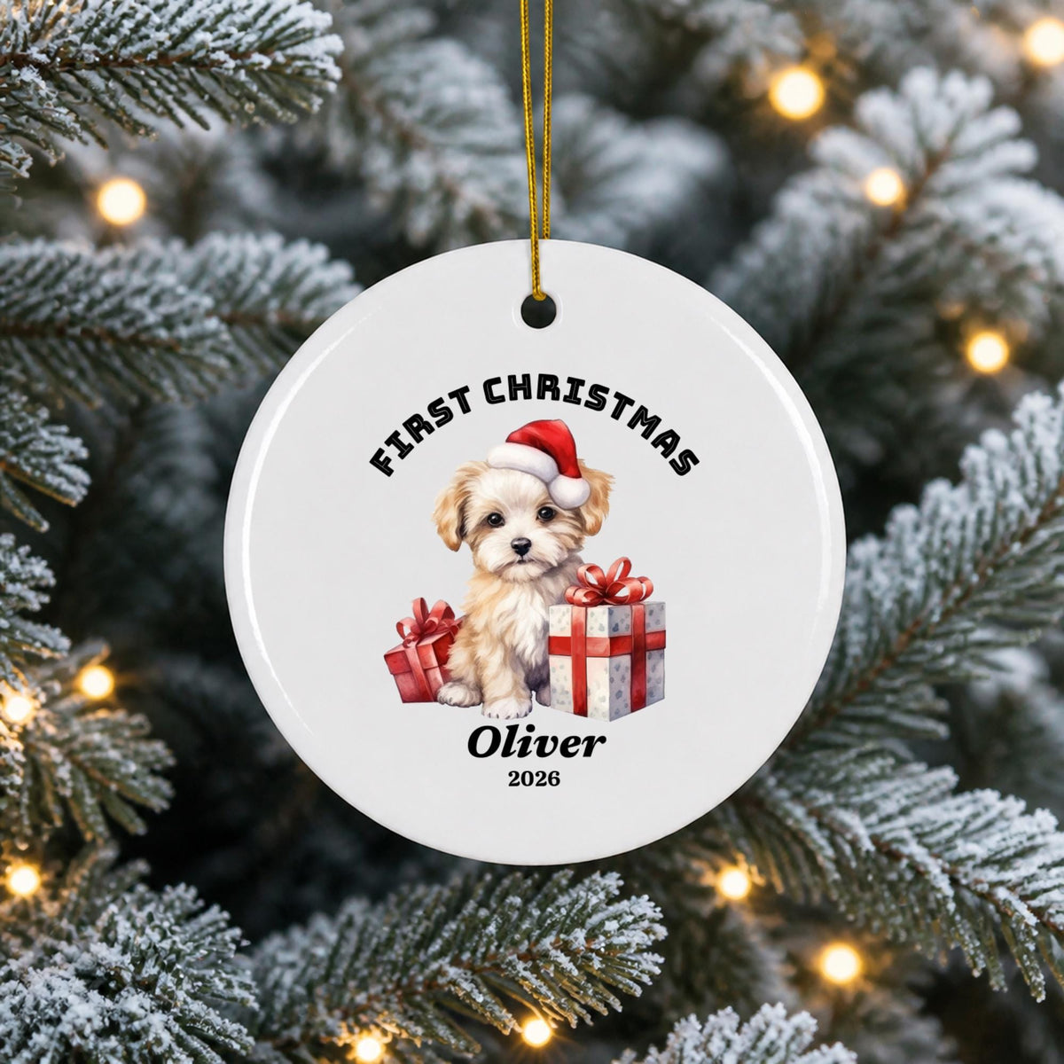 Personalized white ceramic First Christmas ornament hanging from a snowy evergreen tree, featuring a festive Santa illustration, custom name Oliver, and warm holiday lights.