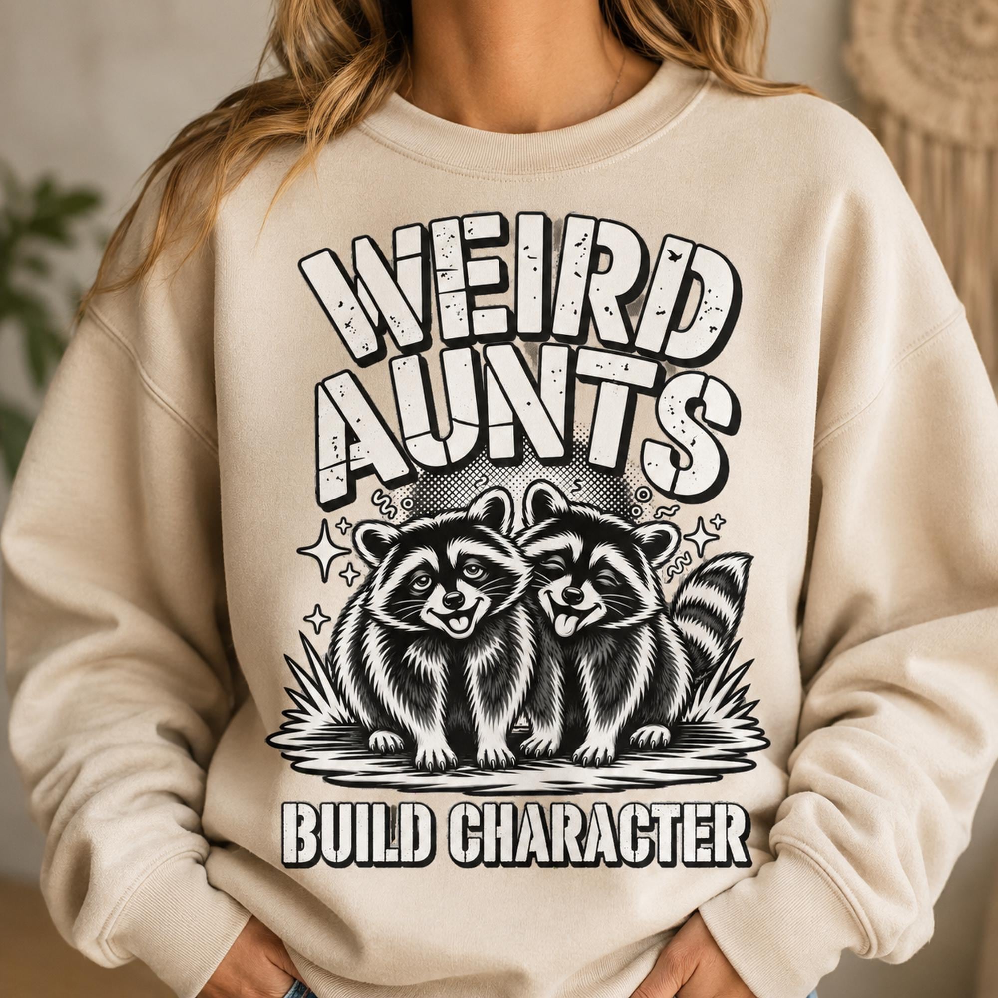 Weird Aunts Build Character raccoon graphic displayed on a cream crewneck sweatshirt in a cozy lifestyle mockup.