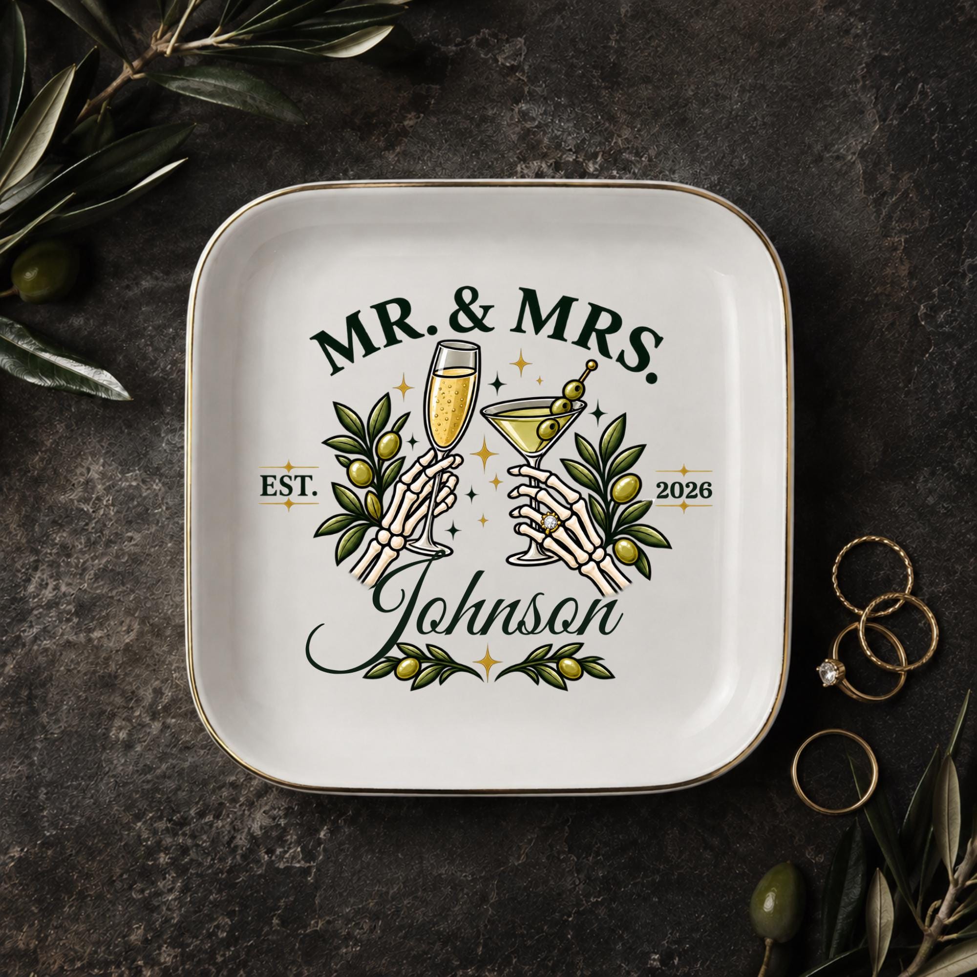 Personalized Mr and Mrs jewelry dish with skeleton hands holding champagne and martini glasses, olive branches, last name, and year.