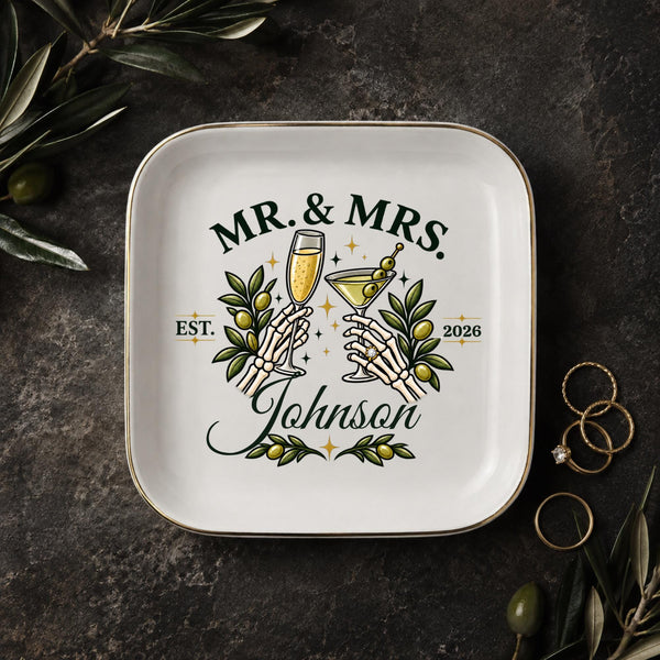 Personalized Mr and Mrs jewelry dish with skeleton hands holding champagne and martini glasses, olive branches, last name, and year.
