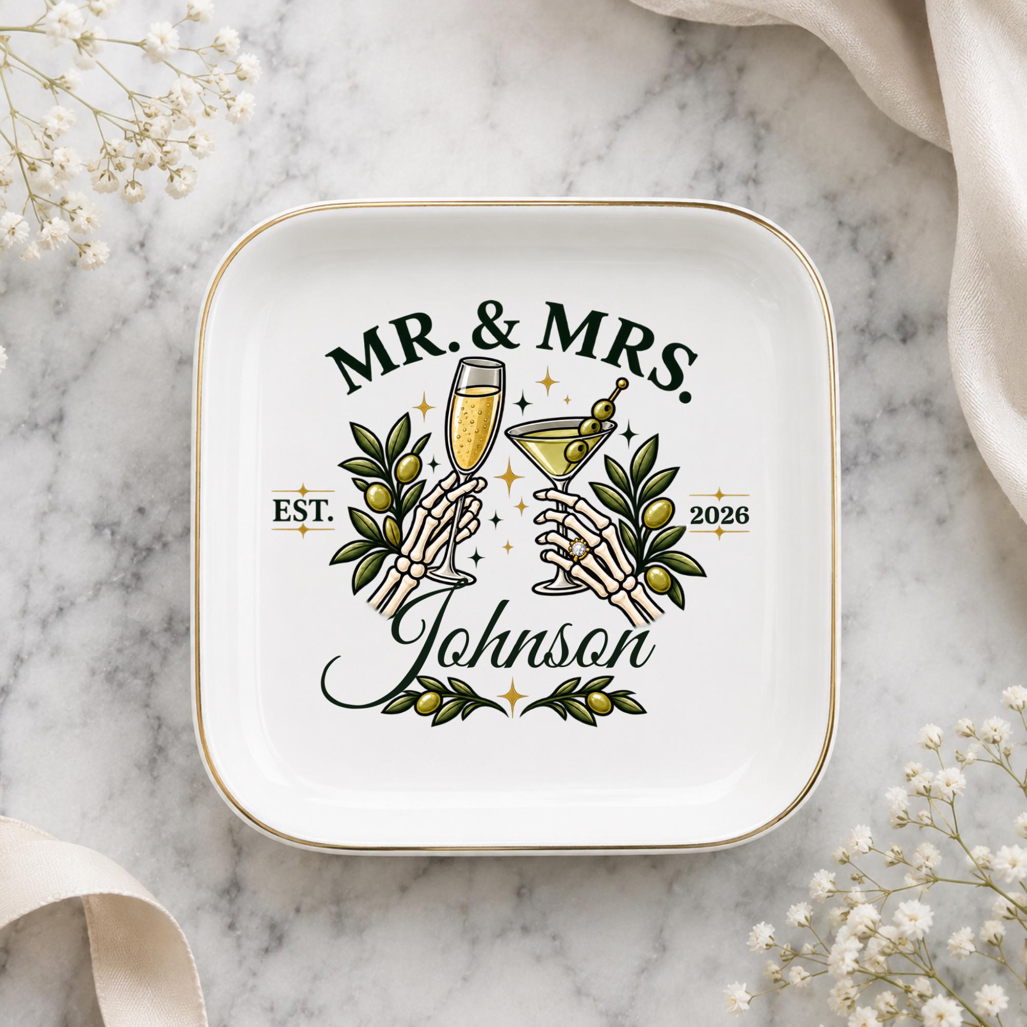 Gothic wedding ring dish featuring Mr and Mrs text, skeletal hands, green olives, cocktail glasses, and custom family name.
