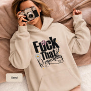 Woman wearing a sand Gildan 18500 hoodie with “Fuck That Respectfully” graphic, daisy accents, script text, and warm neutral blanket styling.