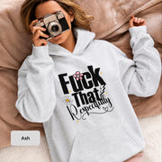 Woman wearing an ash Gildan 18500 hoodie featuring a bold “Fuck That Respectfully” floral graphic while holding a vintage camera on a cozy neutral blanket.