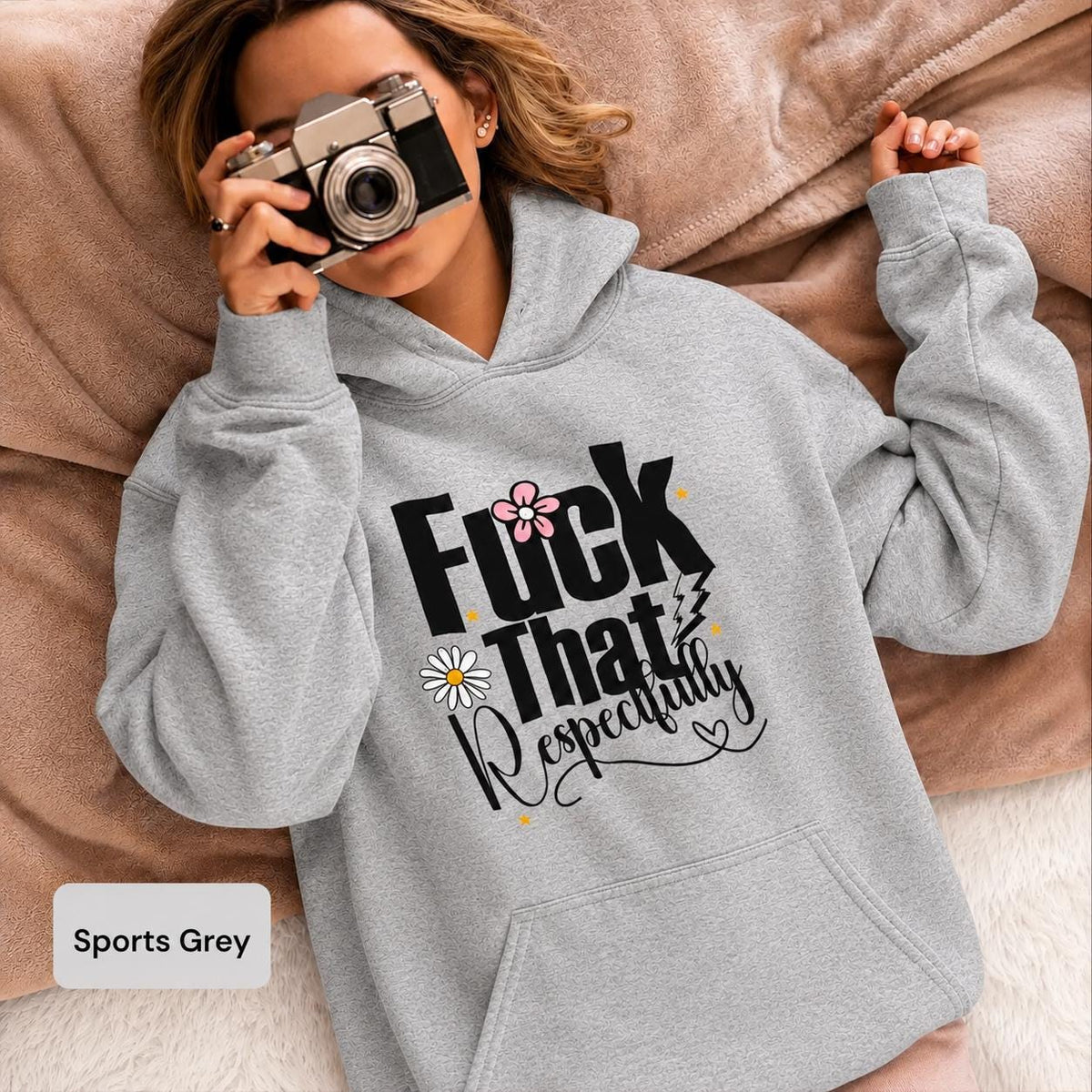 Woman modeling a sports grey Gildan 18500 hoodie with “Fuck That Respectfully” design, floral accents, and vintage camera lifestyle styling.