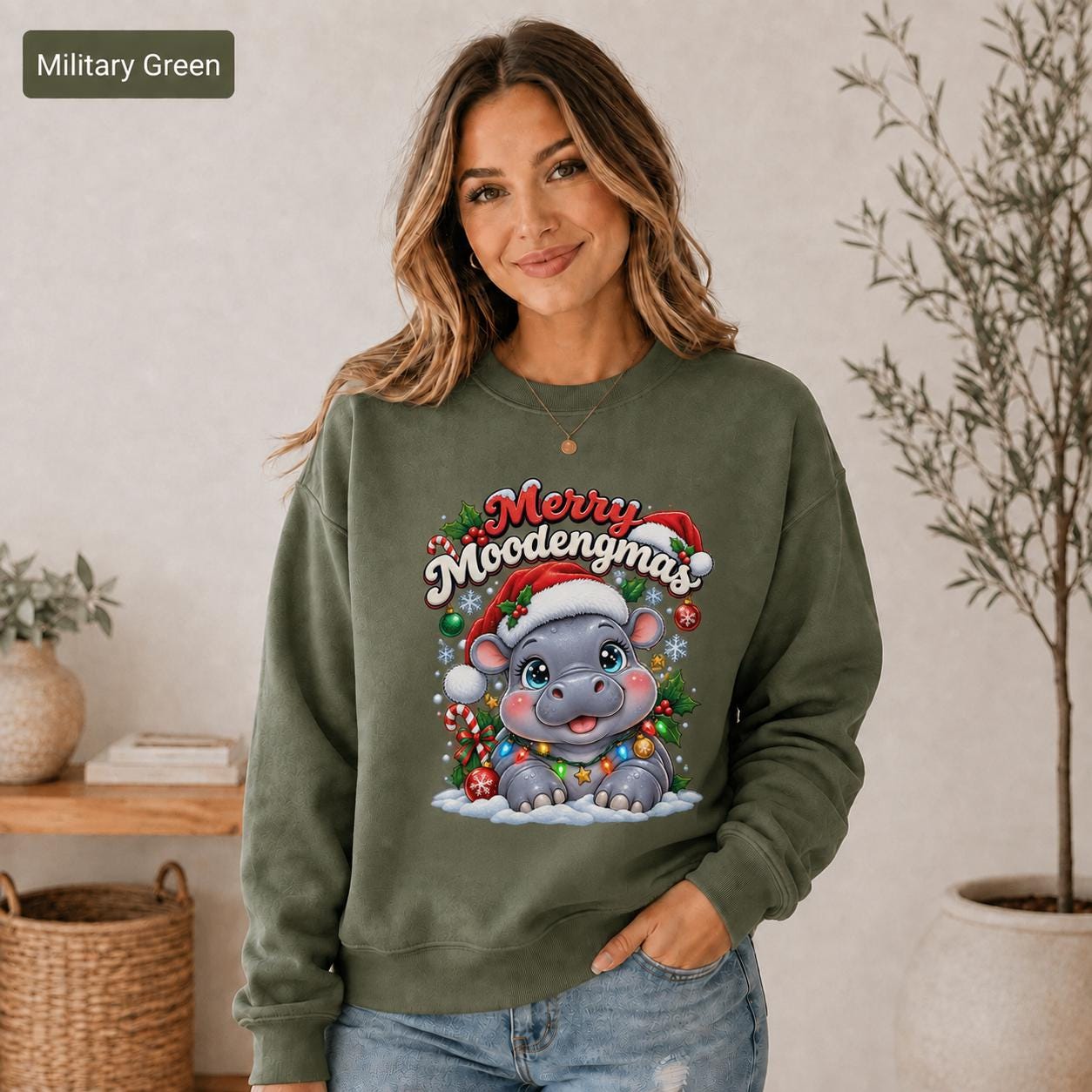 Military green Christmas sweatshirt featuring a cute hippo in a Santa hat with Merry Moodengmas text, candy canes, ornaments, holly, and snowflakes.