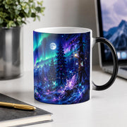 Aurora borealis mug with blue, green, and purple night sky artwork over a snowy woodland landscape.