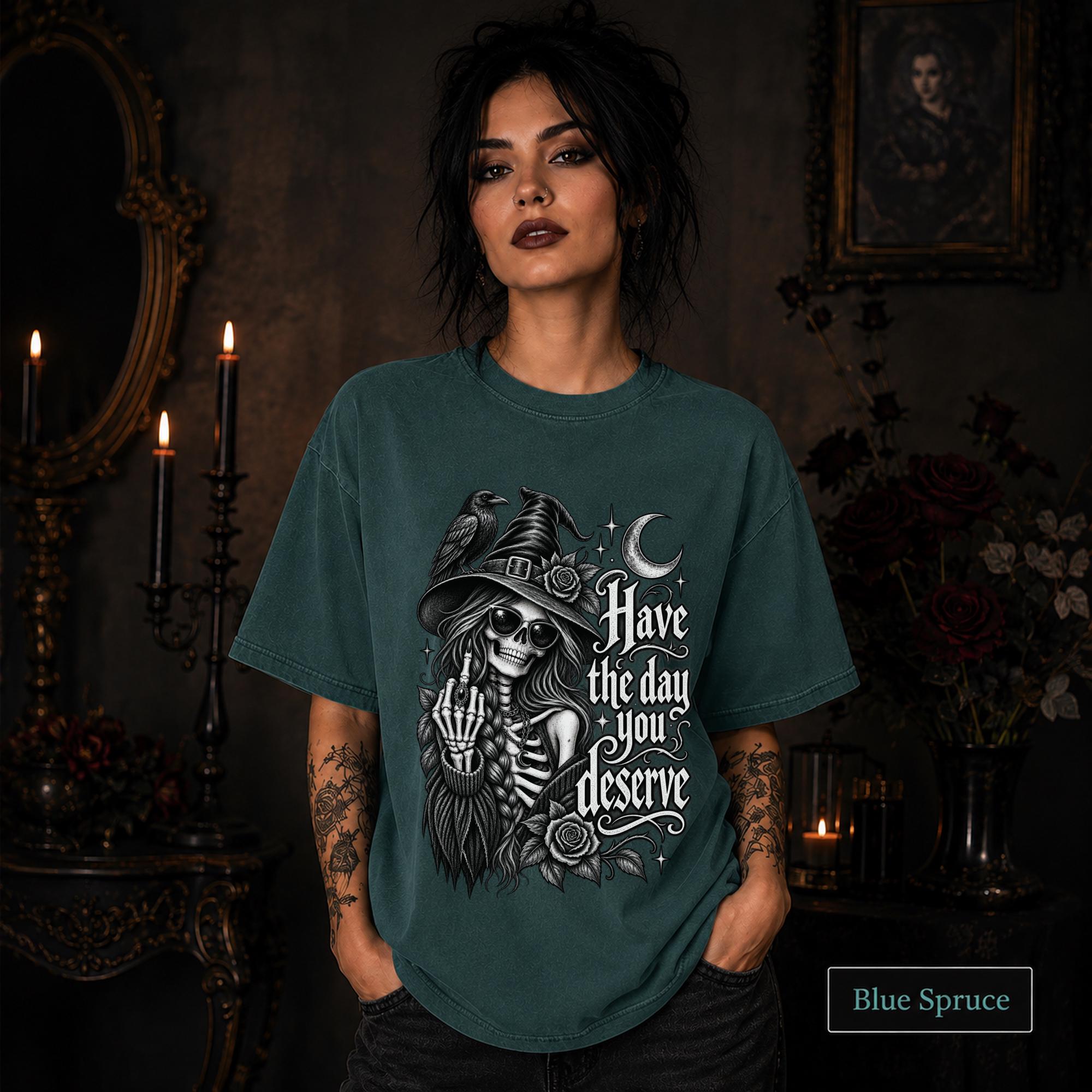 Blue spruce witchy graphic tee with skeletal woman in pointed hat, dark floral artwork, raven, and moon details.