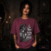 Dark humor women’s tee with skeleton witch, black raven, roses, stars, and crescent moon illustration.
