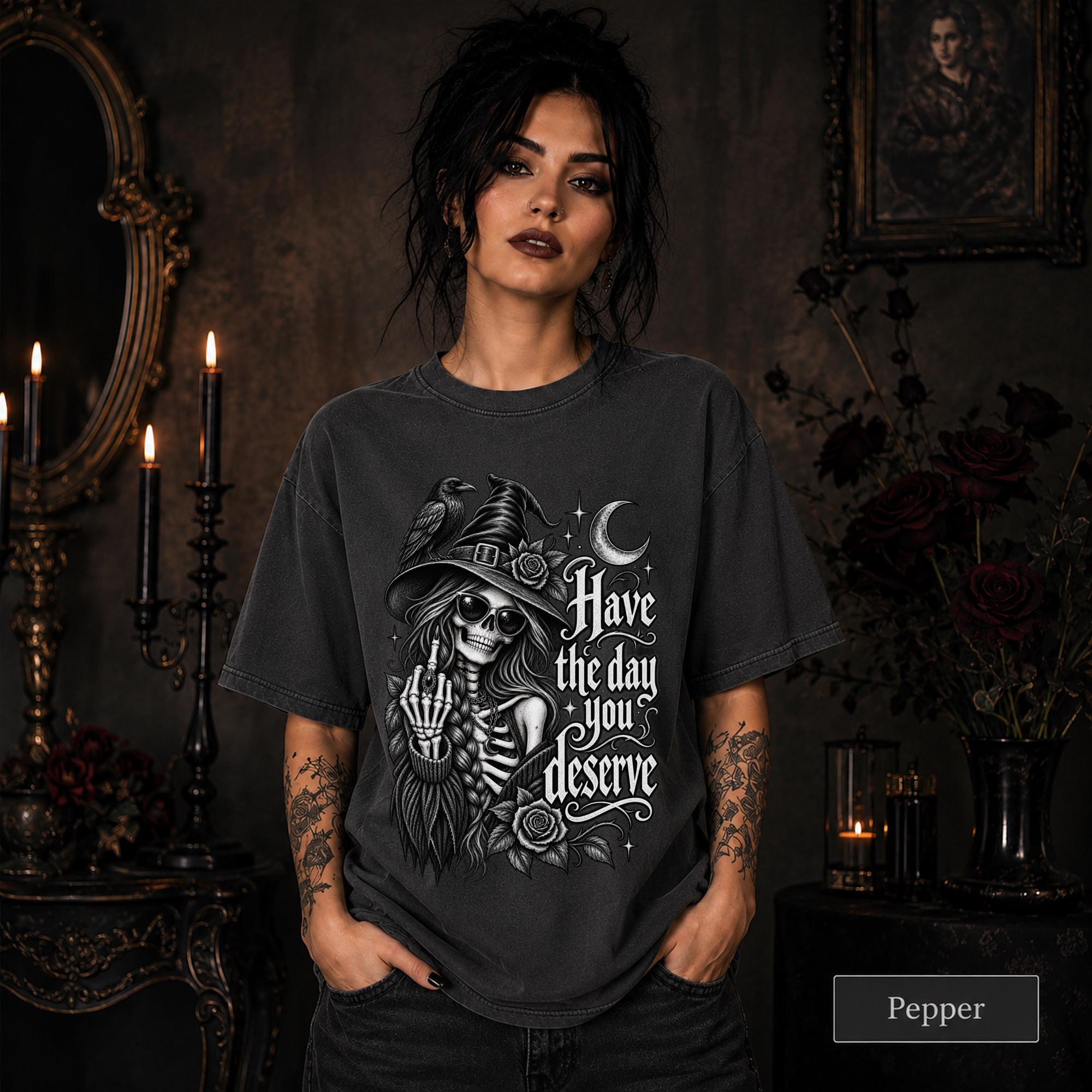 Witchy clothing design with skeletal woman wearing sunglasses and pointed hat beside a raven.