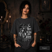 Witchy clothing design with skeletal woman wearing sunglasses and pointed hat beside a raven.