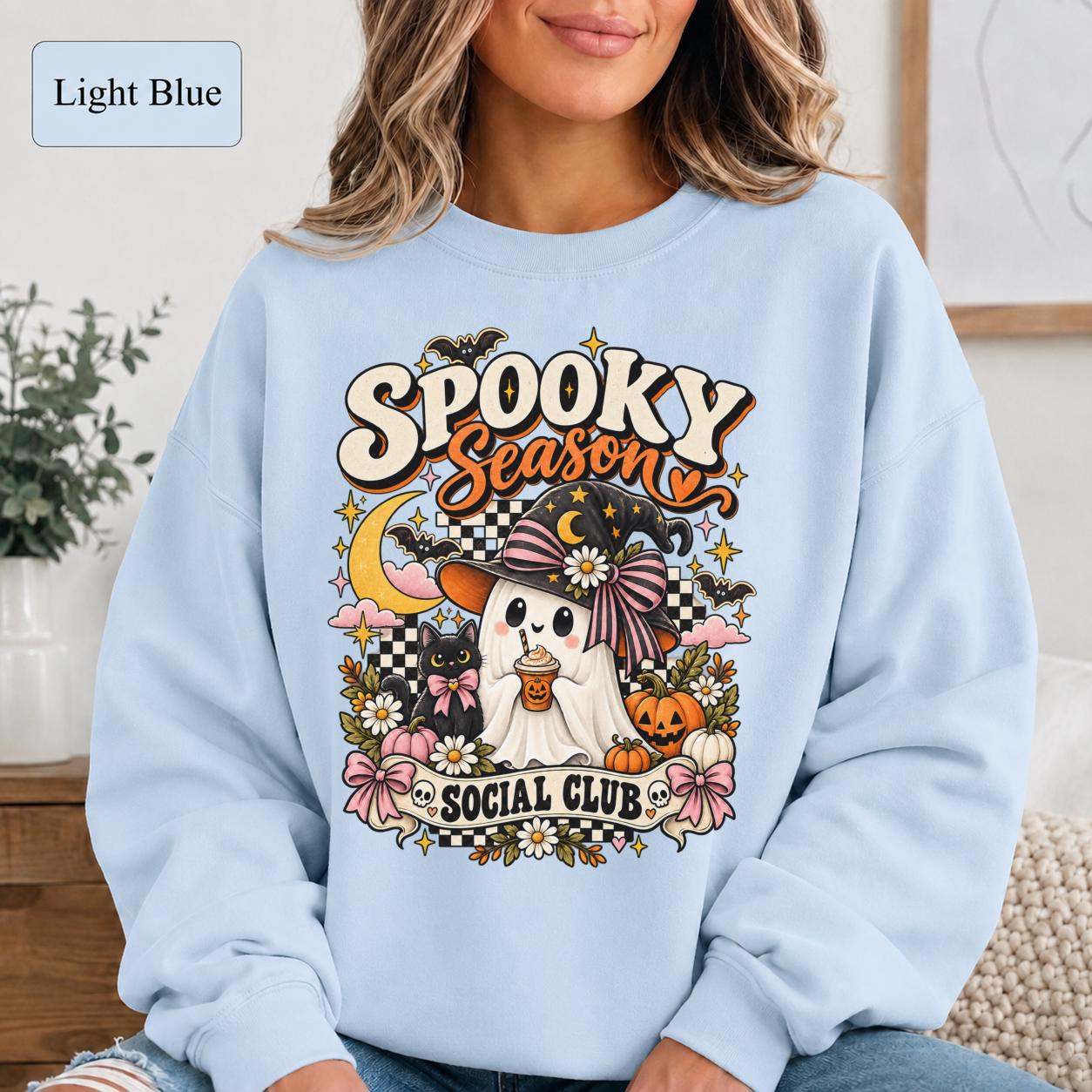 Coquette Halloween shirt featuring pink bows, ghost character, black cat, pumpkins, and floral details.