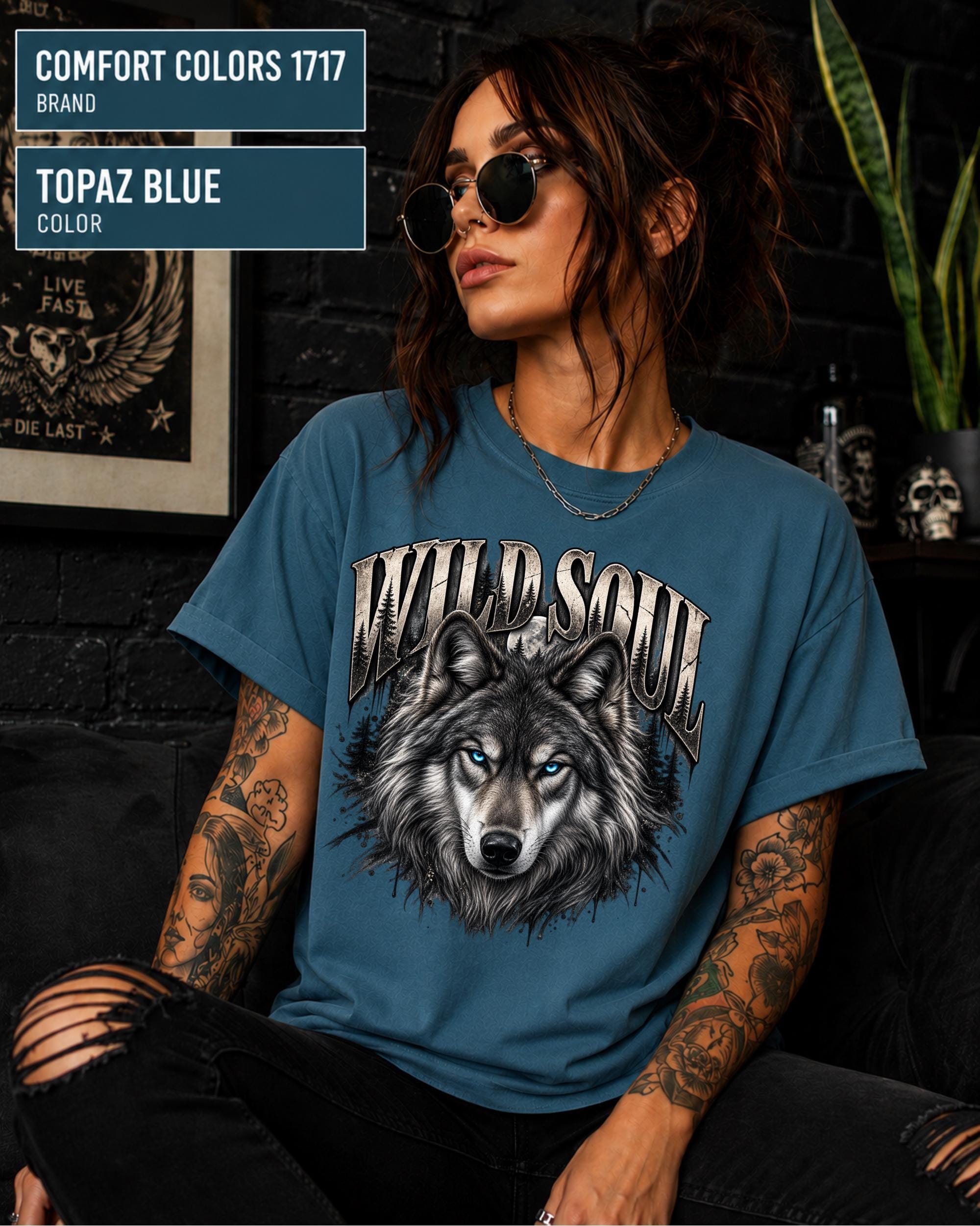 Wild Soul wolf graphic Comfort Colors 1717 T-shirt in topaz blue featuring a detailed gray wolf with bright blue eyes and forest-inspired artwork.