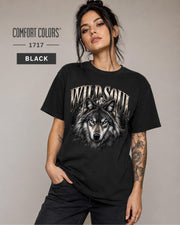 Wild Soul wolf graphic Comfort Colors 1717 T-shirt in black featuring a detailed gray wolf with bright blue eyes and forest-inspired artwork.