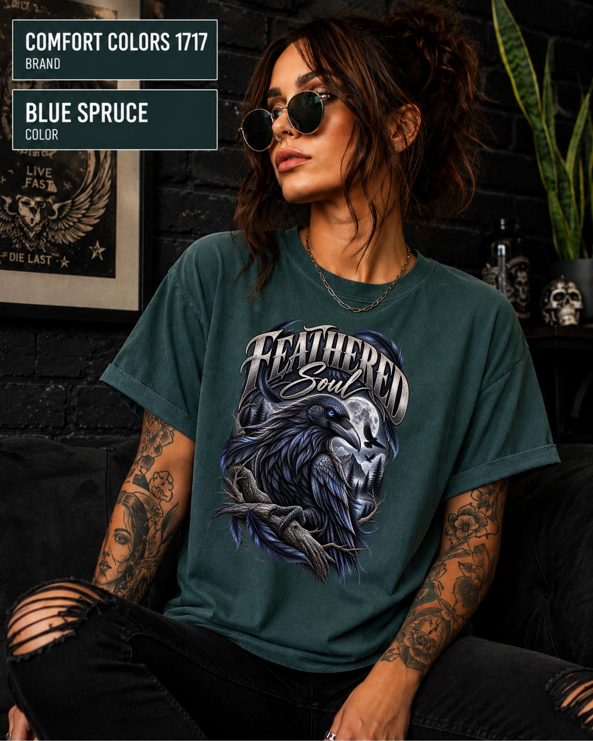 Feathered Soul raven graphic Comfort Colors 1717 T-shirt in blue spruce featuring a detailed black raven with a blue eye, moonlit forest, branches, and gothic artwork.