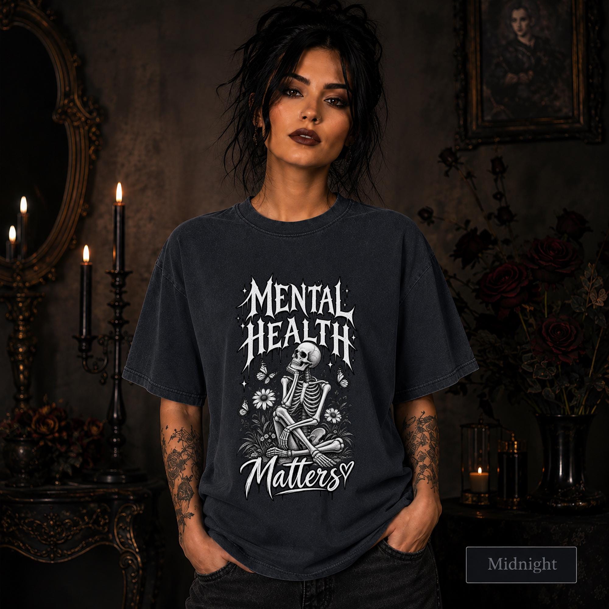 Mental Health Matters midnight T-shirt featuring a seated skeleton, flowers, butterflies, and bold gothic lettering in a monochrome design.
