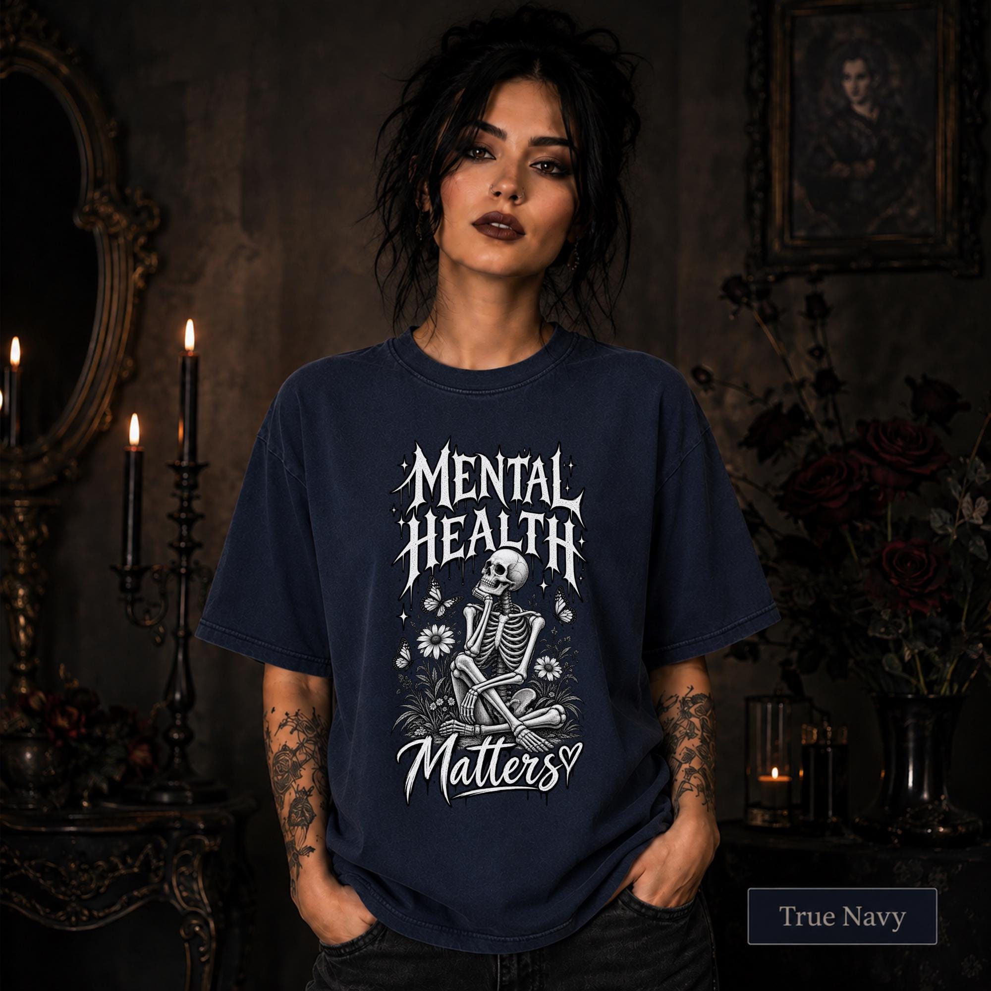 Mental Health Matters true navy T-shirt featuring a seated skeleton, flowers, butterflies, and bold gothic lettering in a monochrome design.