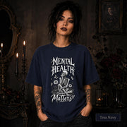 Mental Health Matters true navy T-shirt featuring a seated skeleton, flowers, butterflies, and bold gothic lettering in a monochrome design.