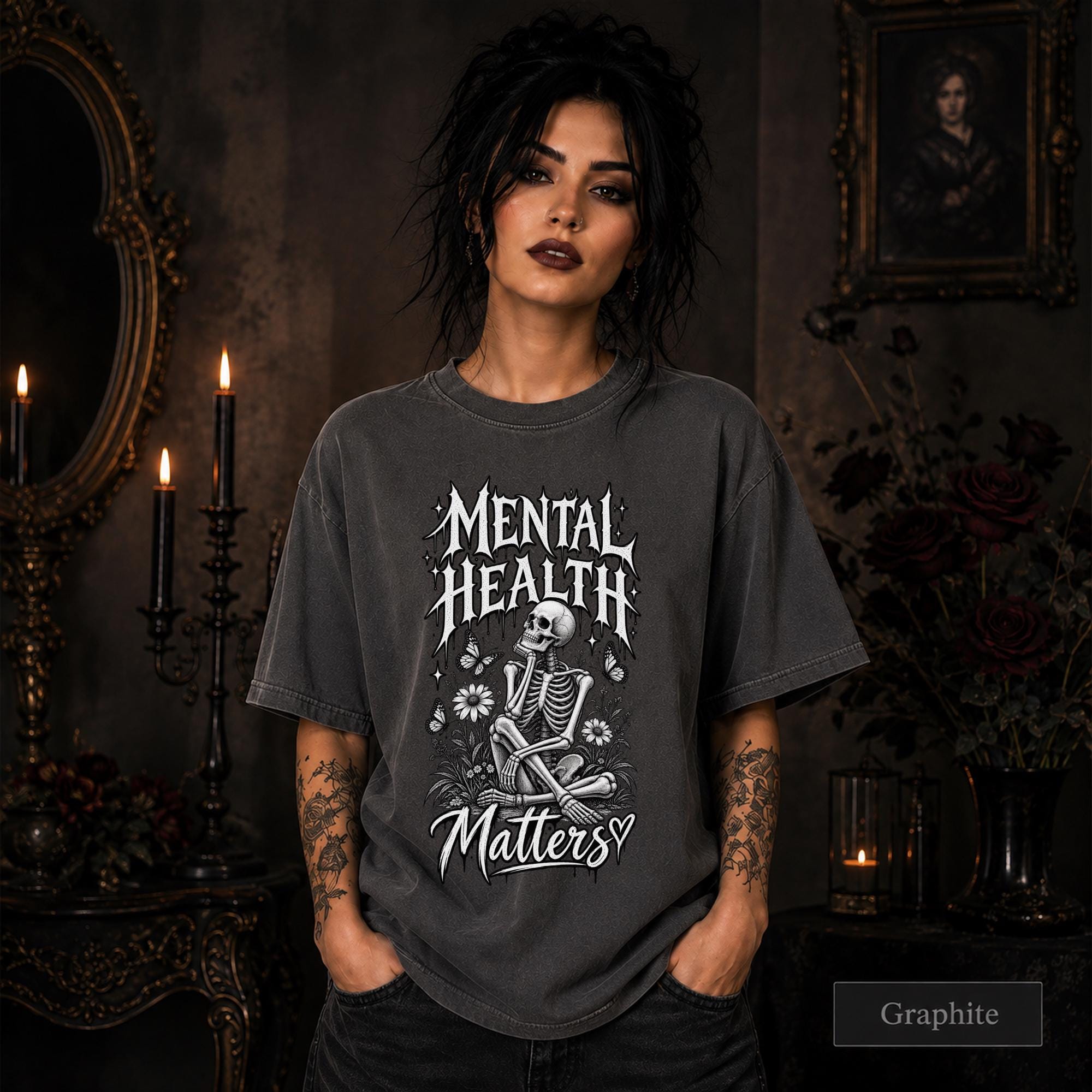 Mental Health Matters graphite T-shirt featuring a seated skeleton, flowers, butterflies, and bold gothic lettering in a monochrome design.