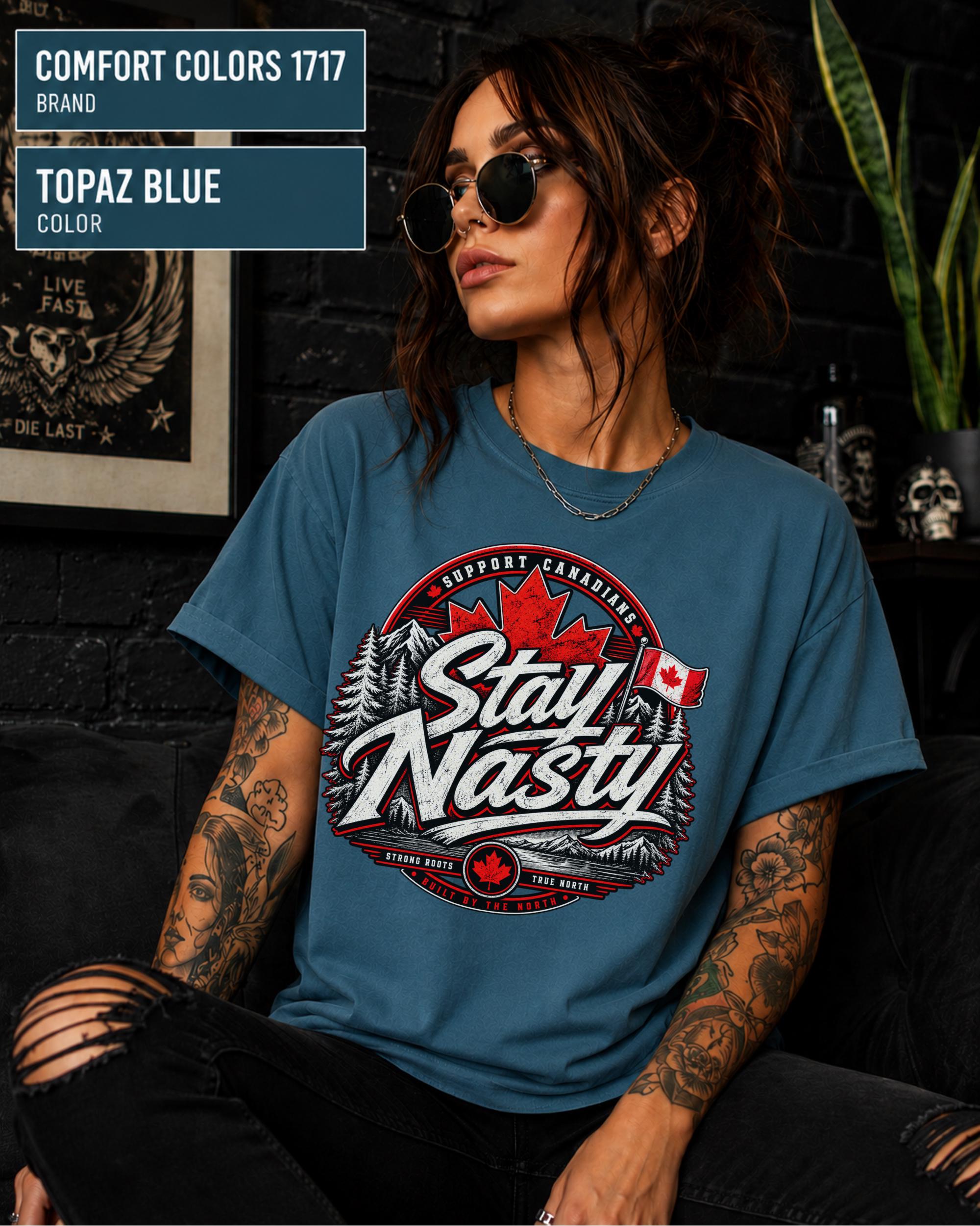 Woman wearing a Topaz Blue Comfort Colors 1717 shirt featuring a Stay Nasty Canadian maple leaf graphic.