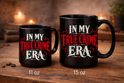 Black In My True Crime Era mugs in 11 oz and 15 oz sizes featuring bold red and cream gothic lettering on ceramic coffee cups.