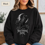 Woman wearing a blackl crewneck sweatshirt featuring a detailed black raven surrounded by a crescent moon, thorny roses, and Nocturnal Soul lettering.