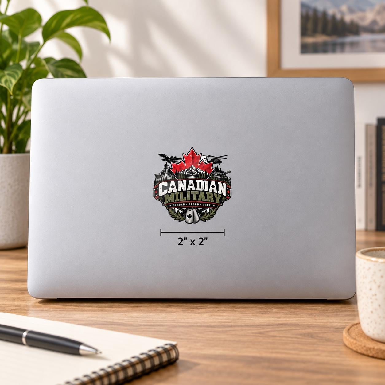 2x2 inch Canadian Military UV DTF sticker mockup on a silver laptop featuring a red maple leaf, military aircraft, ship, tank, mountains, and “Strong Proud True” text.