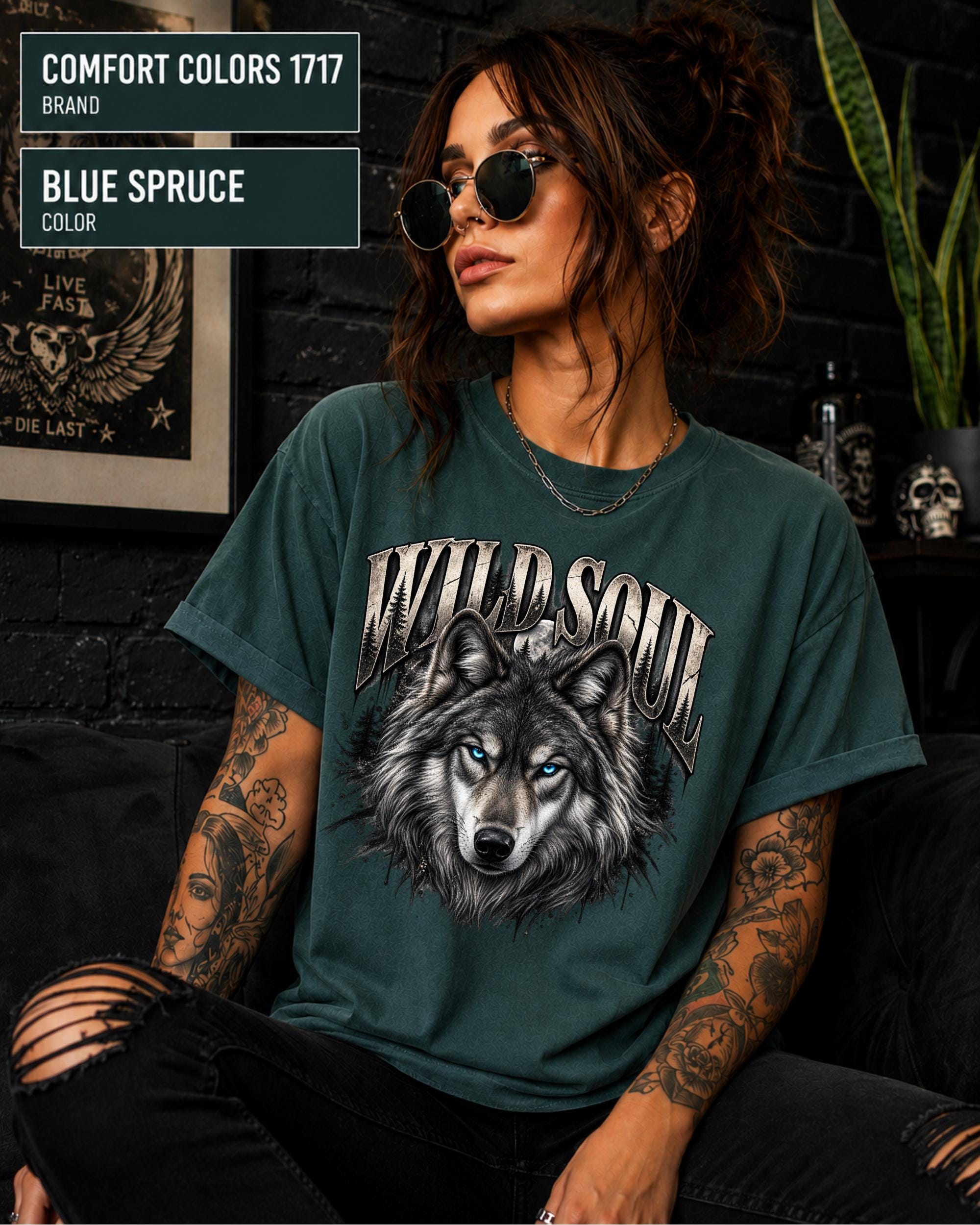 Wild Soul wolf graphic Comfort Colors 1717 T-shirt in blue spruce featuring a detailed gray wolf with bright blue eyes and forest-inspired artwork.