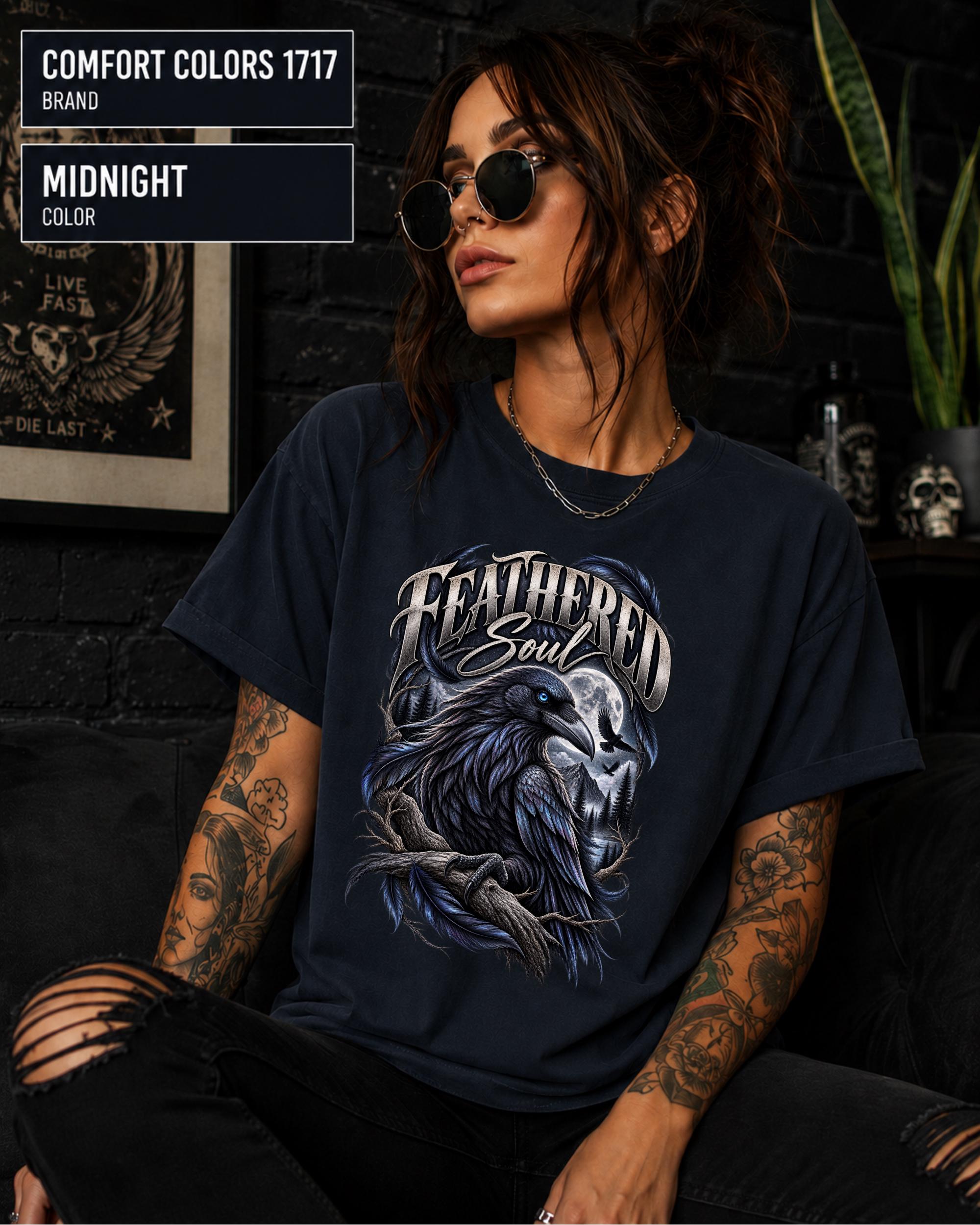 Feathered Soul raven graphic Comfort Colors 1717 T-shirt in midnight featuring a detailed black raven with a blue eye, moonlit forest, branches, and gothic artwork.