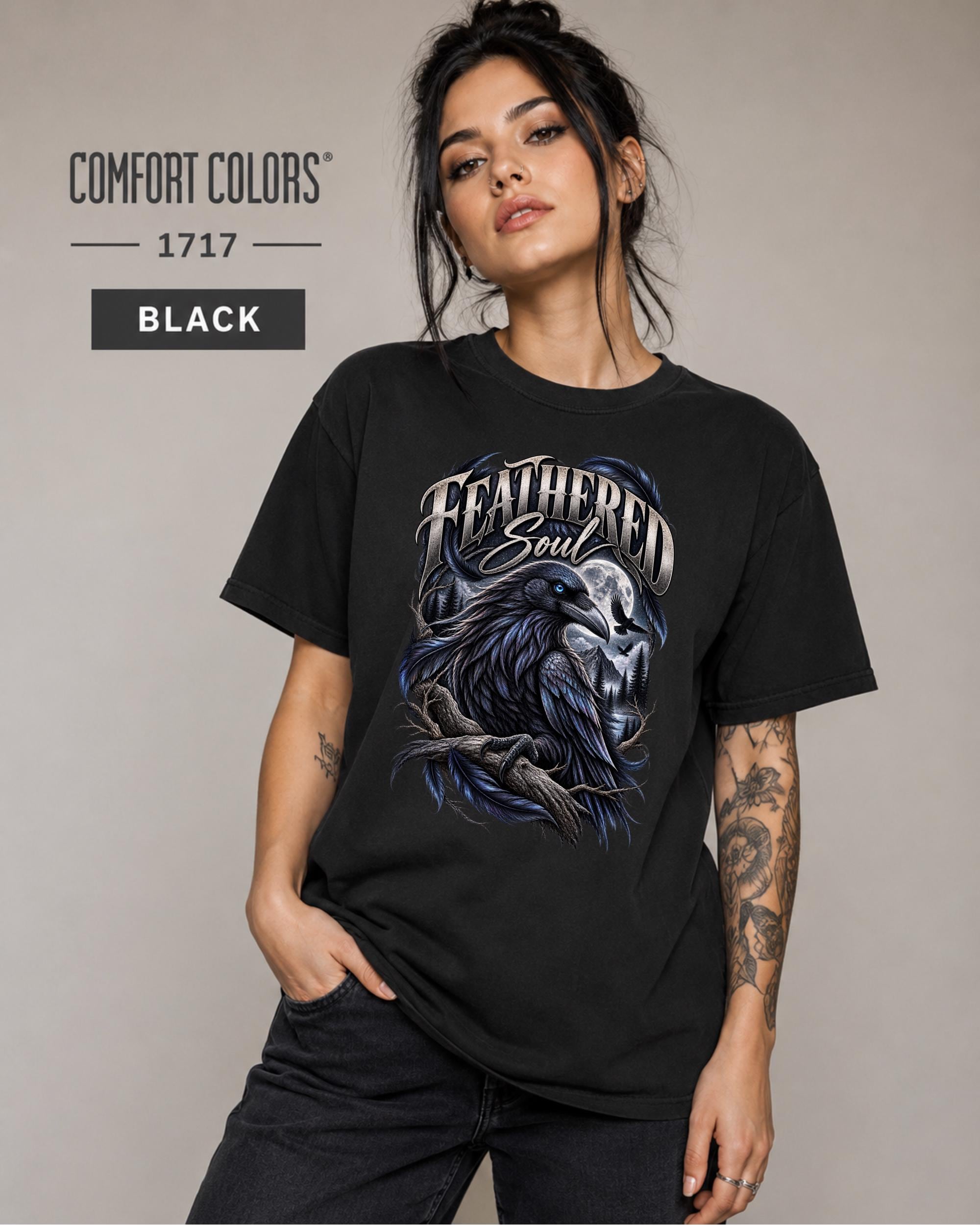 Feathered Soul raven graphic Comfort Colors 1717 T-shirt in black featuring a detailed black raven with a blue eye, moonlit forest, branches, and gothic artwork.