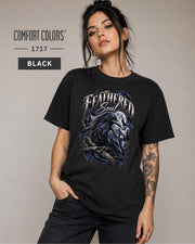 Feathered Soul raven graphic Comfort Colors 1717 T-shirt in black featuring a detailed black raven with a blue eye, moonlit forest, branches, and gothic artwork.