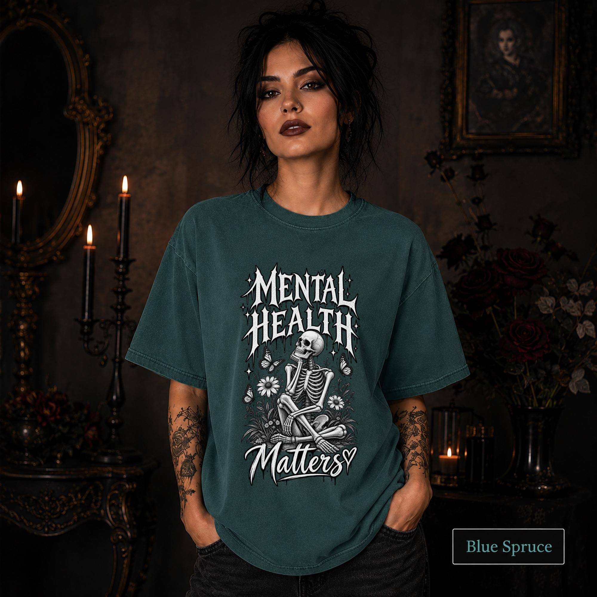 Mental Health Matters blue spruce T-shirt featuring a seated skeleton, flowers, butterflies, and bold gothic lettering in a monochrome design.