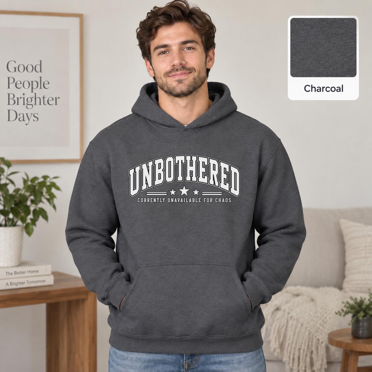 Male model wearing a charcoal Gildan 18500 hoodie with a clean white Unbothered graphic and the phrase Currently Unavailable for Chaos, styled for a minimalist neutral aesthetic.