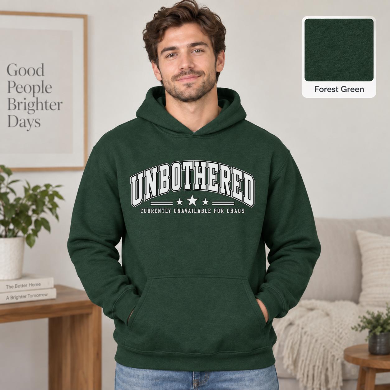Male model wearing a forest green Gildan 18500 hoodie with a clean white Unbothered graphic and the phrase Currently Unavailable for Chaos, styled for a minimalist neutral aesthetic.