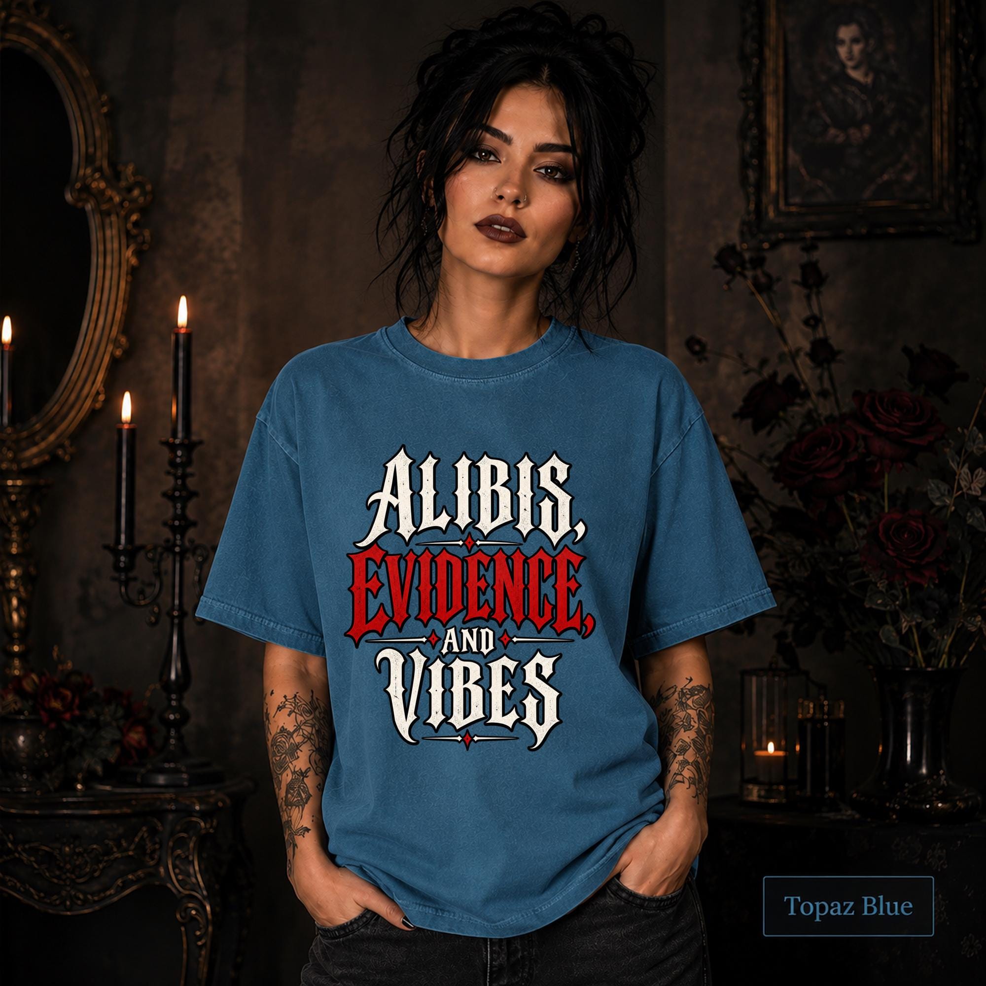 Alibis Evidence and Vibes graphic T-shirt in topaz blue featuring bold red and white gothic lettering on a dark unisex tee.