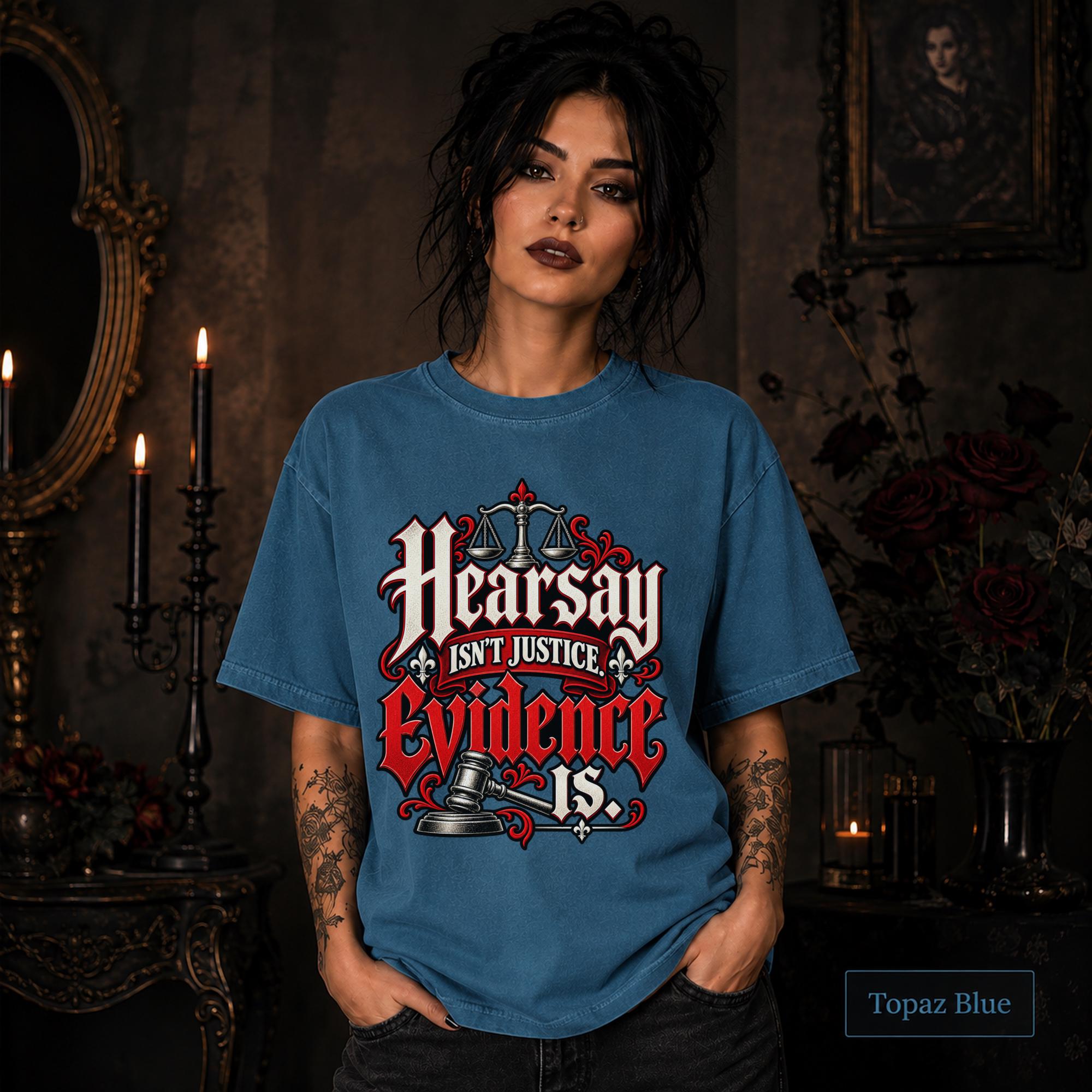 Hearsay Isn’t Justice Evidence Is topaz blue T-shirt featuring red and white gothic lettering, scales of justice, and a judge’s gavel.