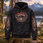 Black camo Protect Wild Places hoodie displayed outdoors in a forest setting, featuring the front graphic and detailed gothic wilderness artwork printed down both sleeves.