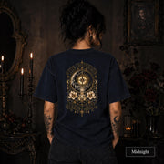 Female model wearing a Midnight Comfort Colors 1717 tee with a large gold celestial graphic reading The Universe Has My Back, featuring compass imagery, mountains, flowers, crystals, stars, and crescent moons.