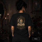 Female model wearing a black Comfort Colors 1717 tee with a large gold celestial graphic reading The Universe Has My Back, featuring compass imagery, mountains, flowers, crystals, stars, and crescent moons.