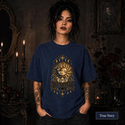 Female model wearing a true navy Comfort Colors 1717 shirt with a gold celestial Abundance design featuring sun and moon faces, crystals, stars, and moon phases.