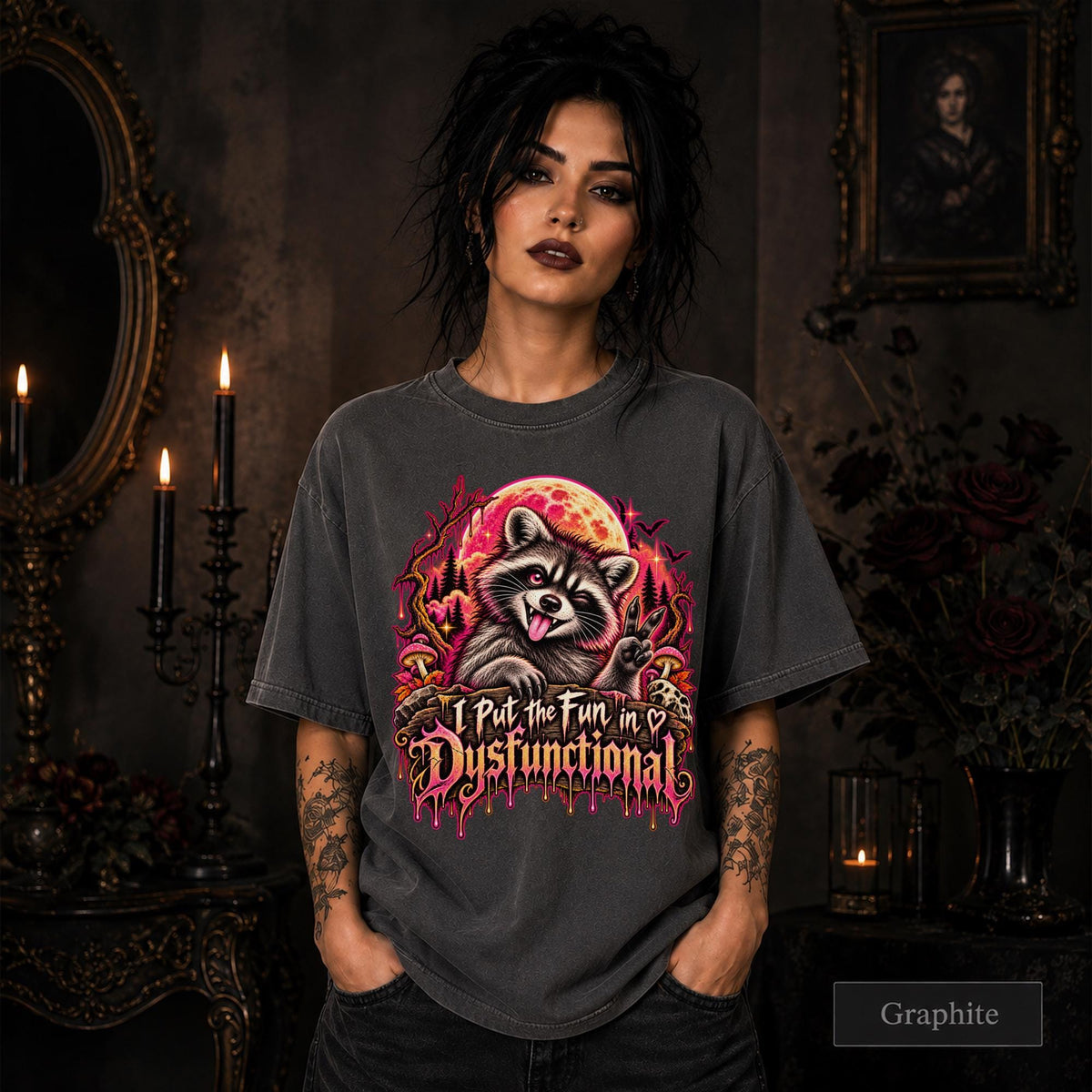 Female model wearing a graphite Comfort Colors 1717 tee featuring a colorful raccoon beneath a glowing moon with mushrooms and the phrase “I Put the Fun in Dysfunctional.”