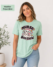 Nurse Boo Crew T-shirt in Heather Prism Mint featuring a cute ghost nurse with a pink cap, stethoscope, clipboard, hearts, and playful Halloween accents.