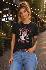 Get Spooky Bookish Babes T-shirt featuring a cute ghost in a pink beanie holding a book and coffee, with hearts and stars on a black heather shirt.