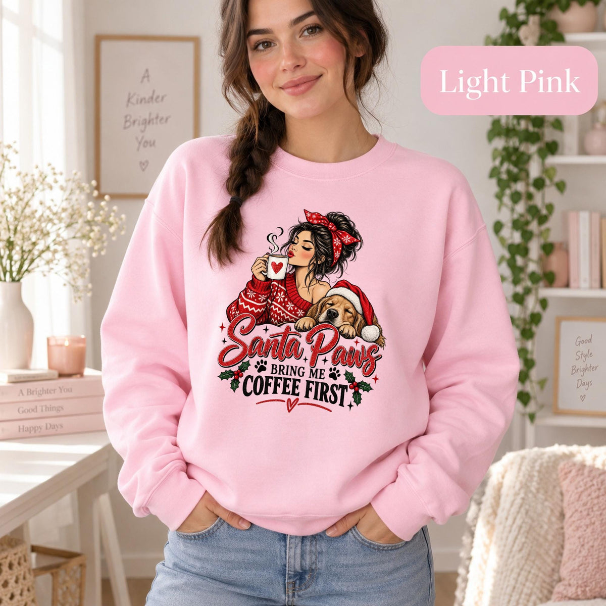 Female model wearing a light pink crewneck sweatshirt featuring the festive “Santa Paws Bring Me Coffee First” pet lover design.