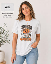 Woman wearing an Ash Bella+Canvas 3001 unisex t-shirt featuring a cute pumpkin nurse graphic and the phrase “Nurse Cute But Clinically Tired.”