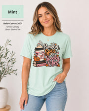 Bella+Canvas 3001 Mint unisex T-shirt featuring a “Pumpkin Spice & Spooky Vibes” design with a ghost reading, fall coffee, stacked books, jack-o’-lantern, hearts, and autumn leaves.