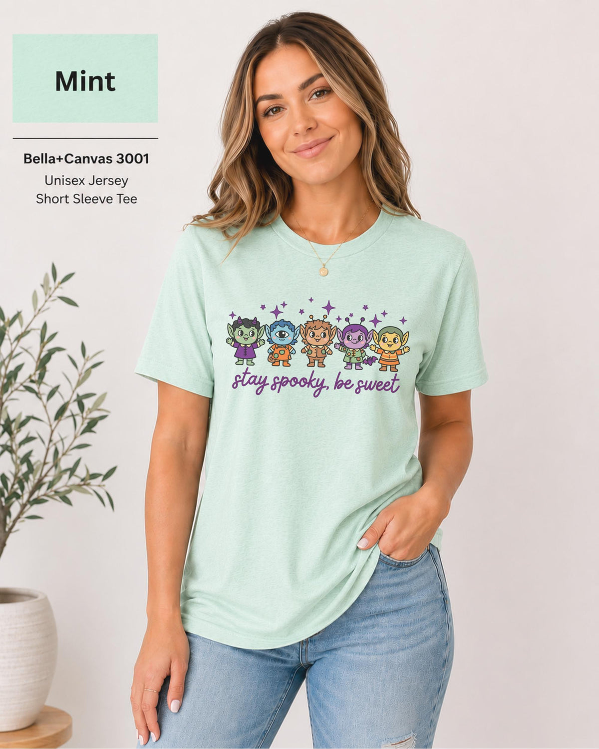 Bella+Canvas 3001 Mint unisex T-shirt featuring five cute Halloween-inspired characters with stars and the phrase “Stay Spooky, Be Sweet” in a small centered chest design.