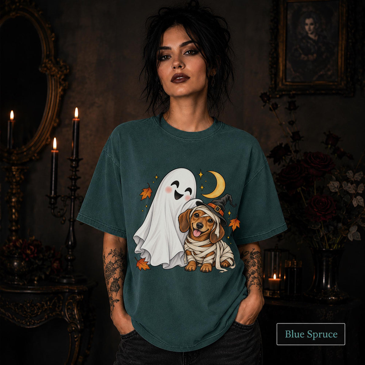 Blue Spruce unisex T-shirt featuring a smiling white ghost beside a mummy-wrapped puppy wearing a witch hat, with a crescent moon, stars, and orange autumn leaves.