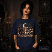 True Navy unisex T-shirt featuring a gothic fantasy scene with a unicorn, owls, raven, crescent moon, mushrooms, candles, flowers, and twisted woodland branches.